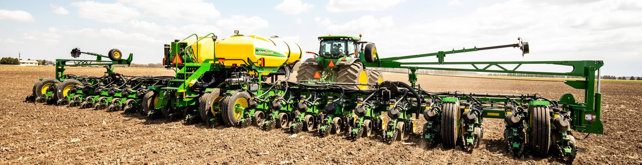 Tractor pulling a planter through a tilled field